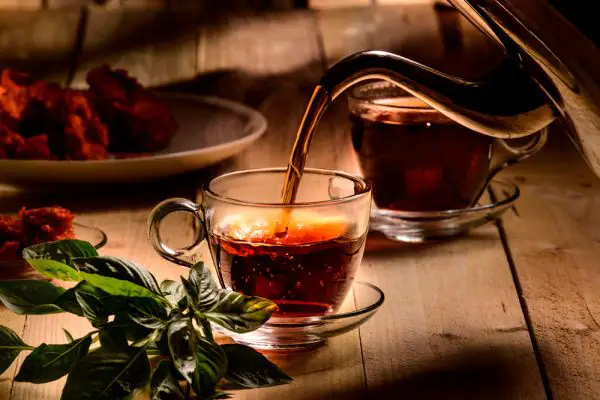 Picture of Hot steaming black tea in a cup on a rustic background