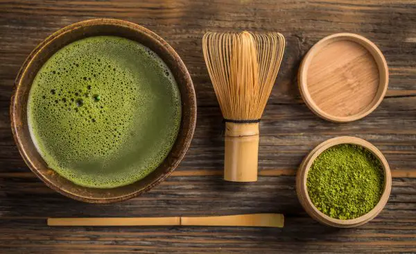 Top view of green tea matcha in a bowl on wooden surface
