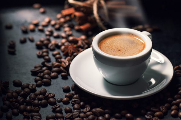Picture of espresso with coffee beans on the background